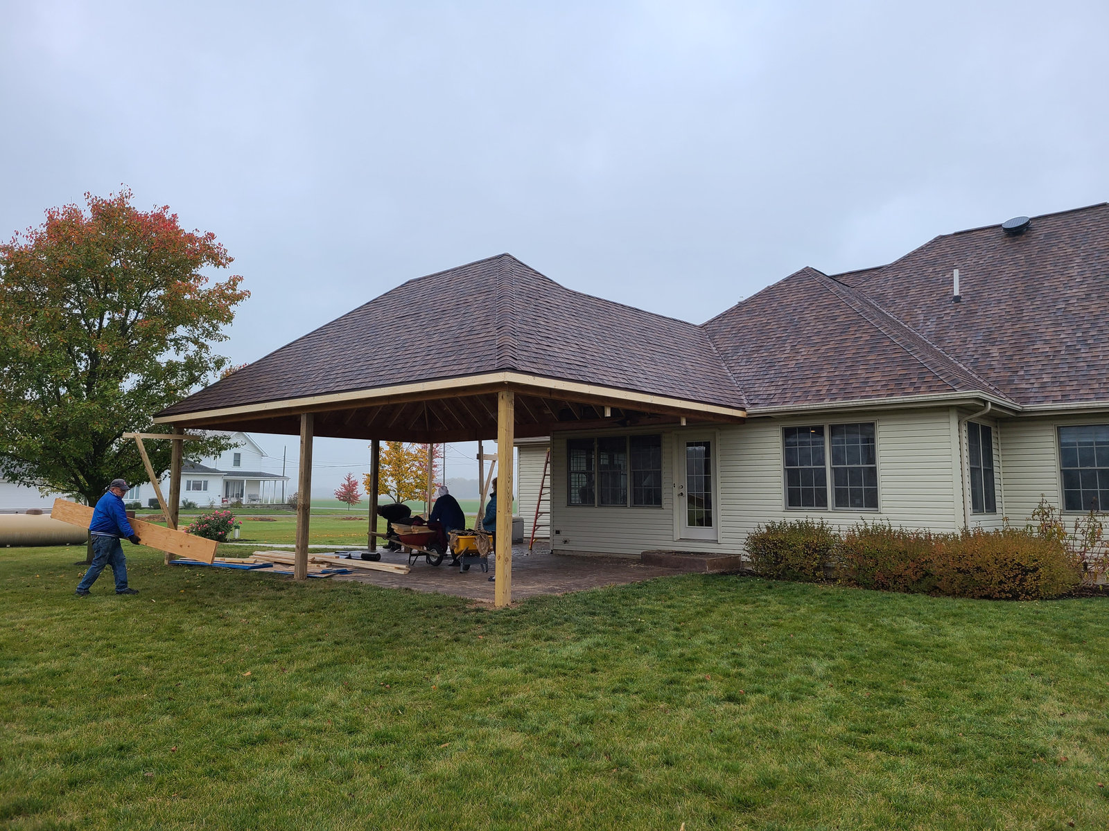 Large open covered porch pavilion addition attached to a brick home