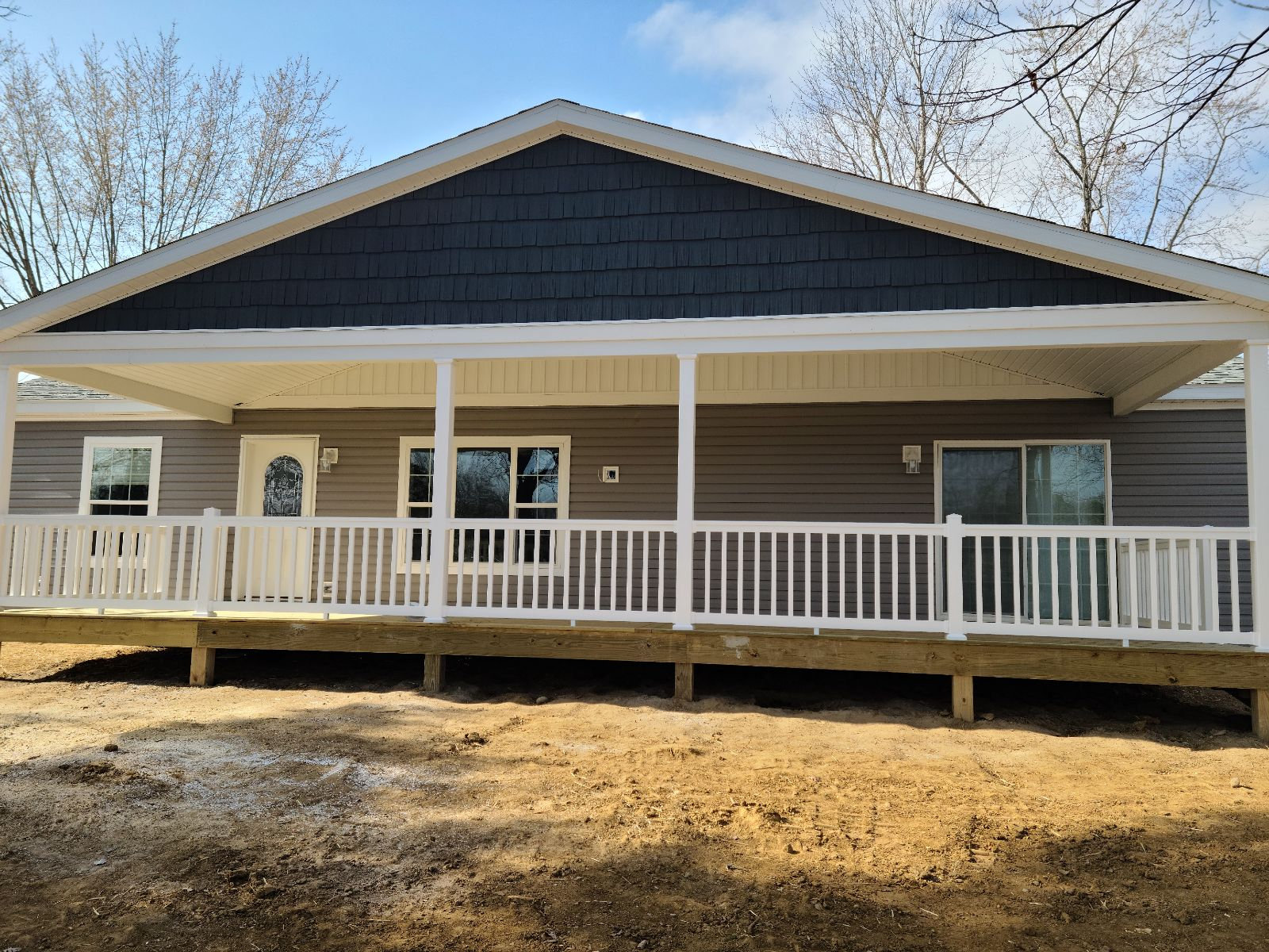 Full width covered front porch with white railing on a remodeled Northern Indiana home
